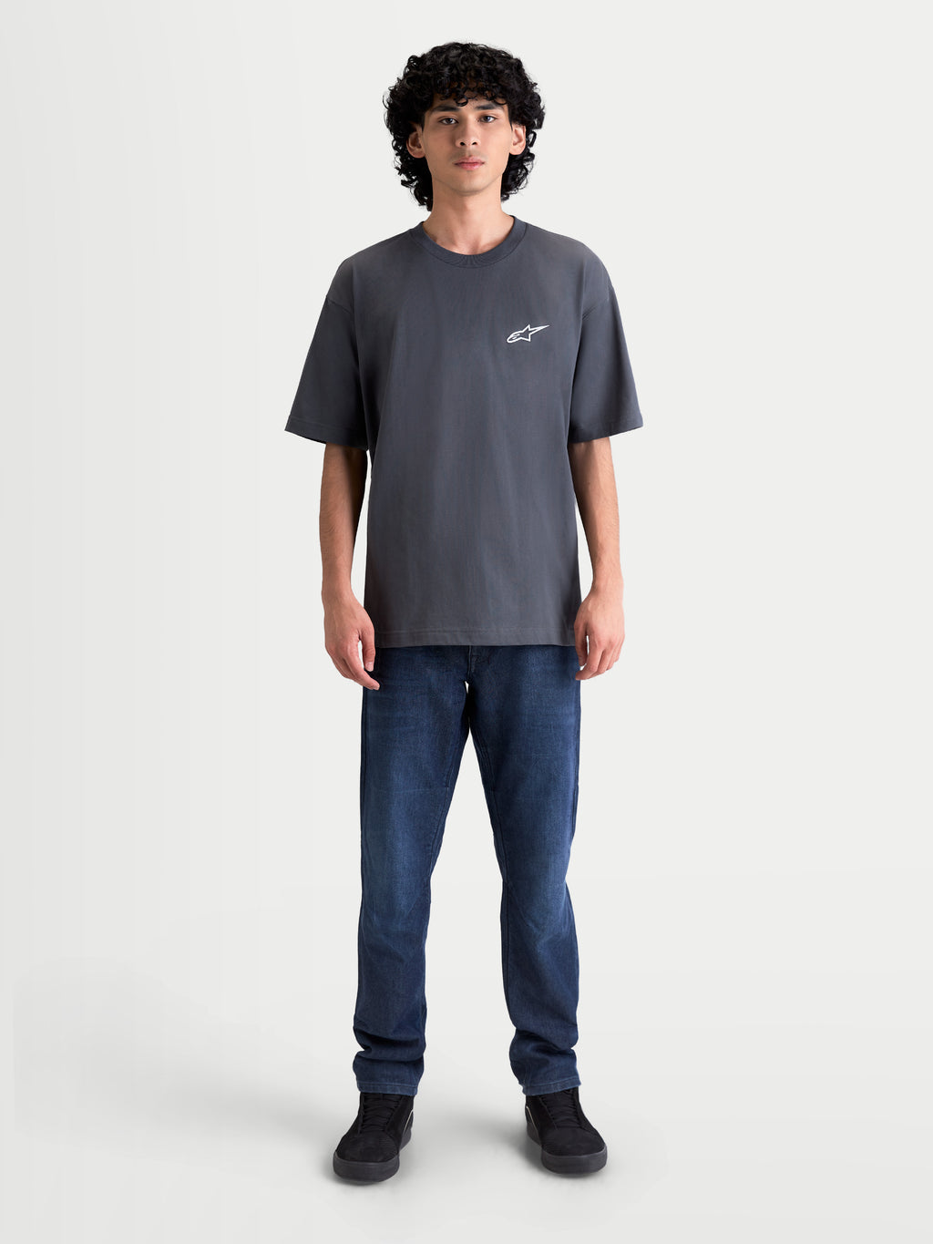 Alpinestars Mandate Oversized CSF t-shirt, kortärmad herr-t-shirt i mörkgrå bomull-polyesterblandning, avslappnad oversized passform med vit pufftryckt Astars-logotyp på bröstet, streetwear-stil.