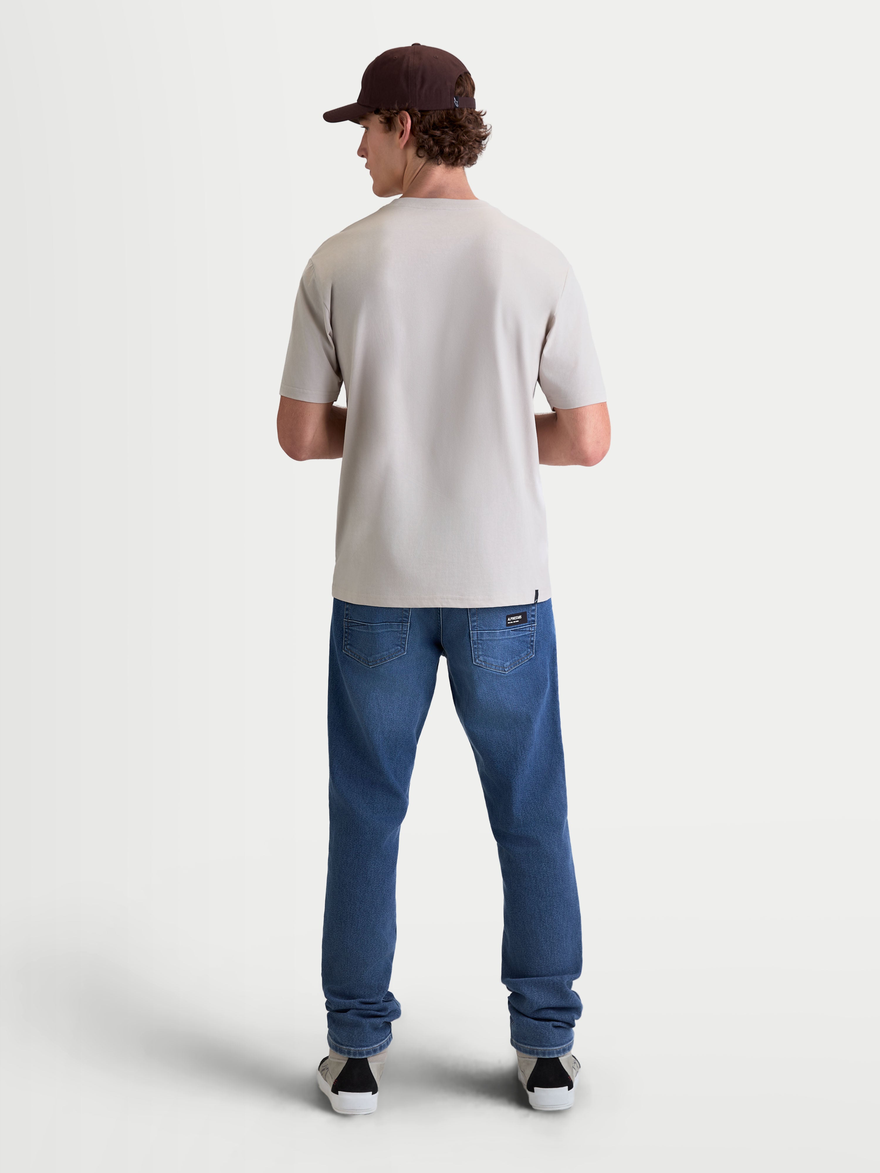 Alpinestars Elliptogrit CSF t-shirt, kortärmad sportswear t-shirt i cementgrå, vy bakifrån på modell, tillverkad i en mjuk bomulls- och polyestermix för en avslappnad motorsport-inspirerad stil.