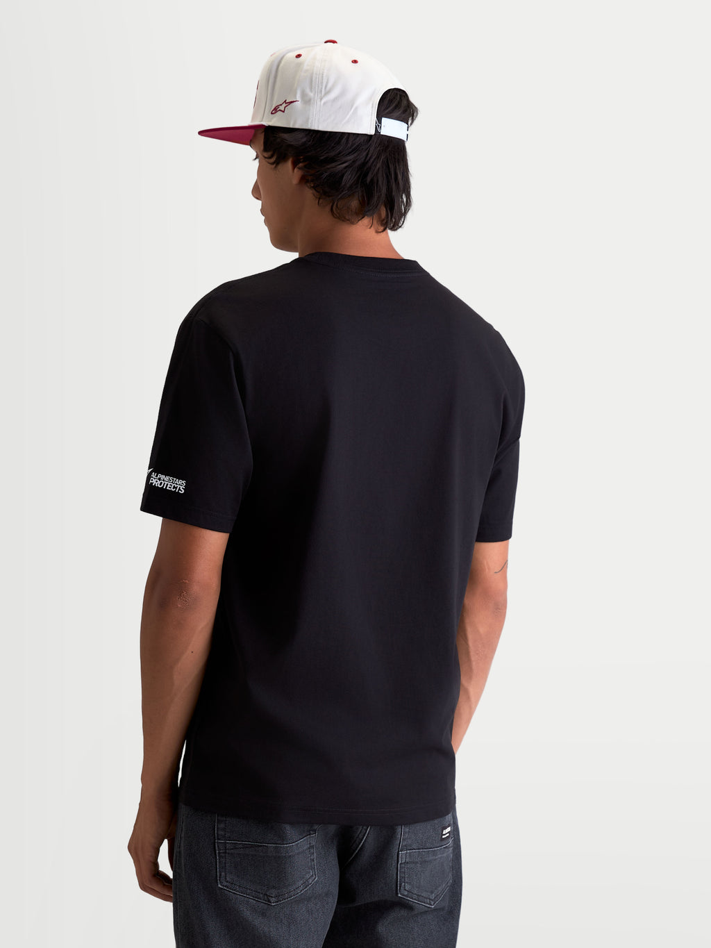 Alpinestars P1 CSF T-shirt, svart kortärmad t-shirt i motorsportstil, ryggvy på modell med vit Alpinestars PROTECTS-logotyp på ärmen, bekväm bomulls- och polyesterblandning.