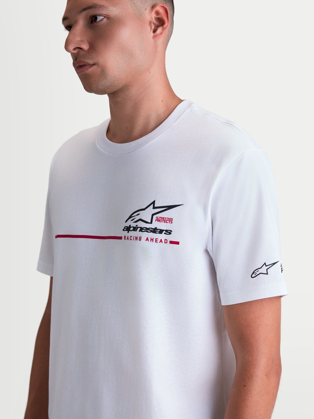 Alpinestars P1 CSF t-shirt, vit kortärmad unisex t-shirt med svart Astars-logotyp, röd racingrand och texten Racing Ahead på bröstet, bekväm bomullsblandning för vardagsbruk.