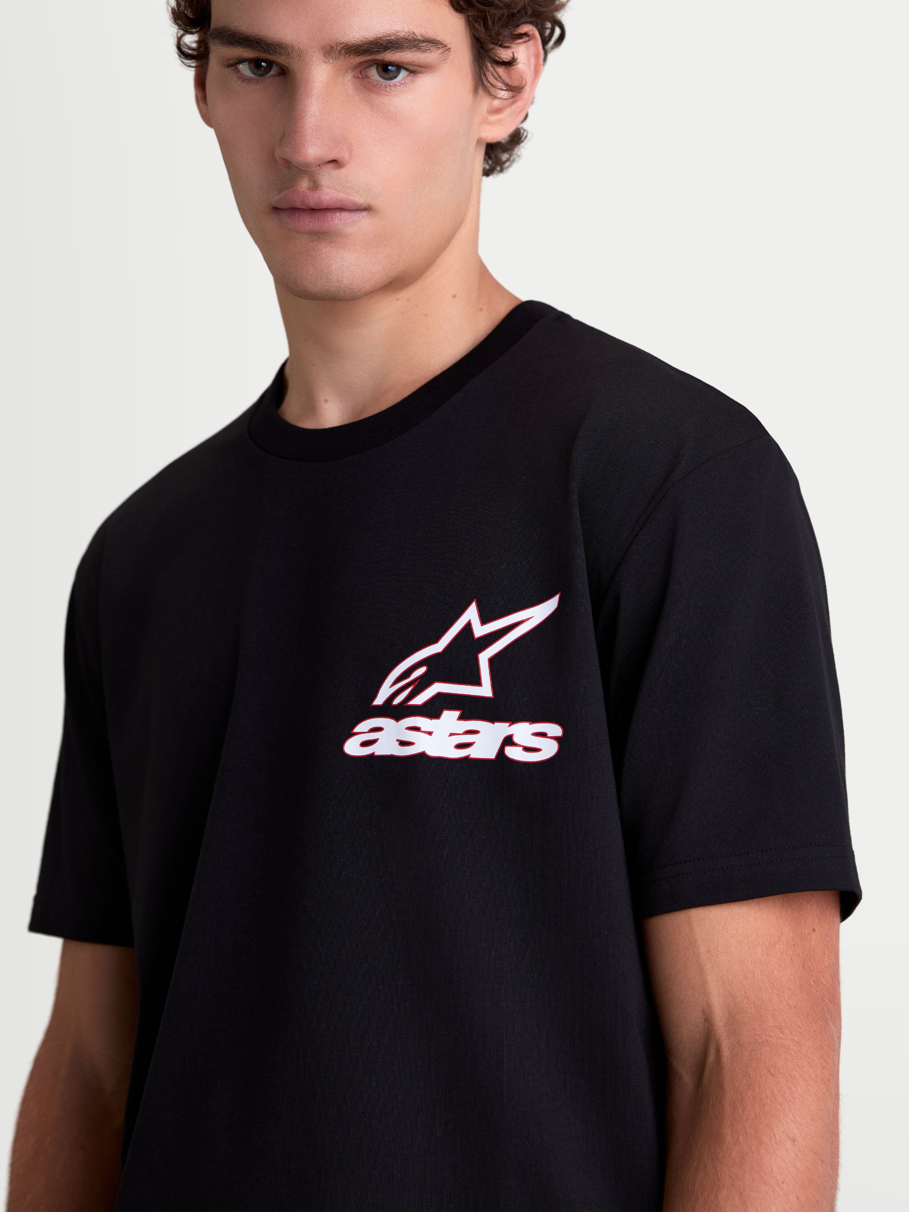 Alpinestars Lineout CSF t-shirt, kortärmad sportswear t-shirt på modell, svart med vit och röd Astars-logotyp på bröstet, mjuk bomull-polyesterblandning, avslappnade livsstilskläder