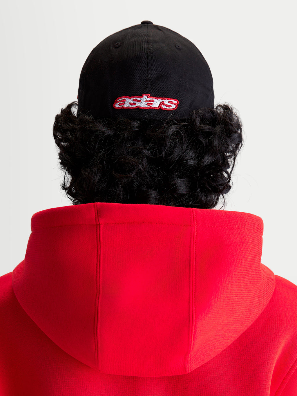 Alpinestars Lineout keps, sportswear keps sedd bakifrån på modell, svart med röd broderad astars-logotyp, strukturerad krona och twillkonstruktion, sportig design