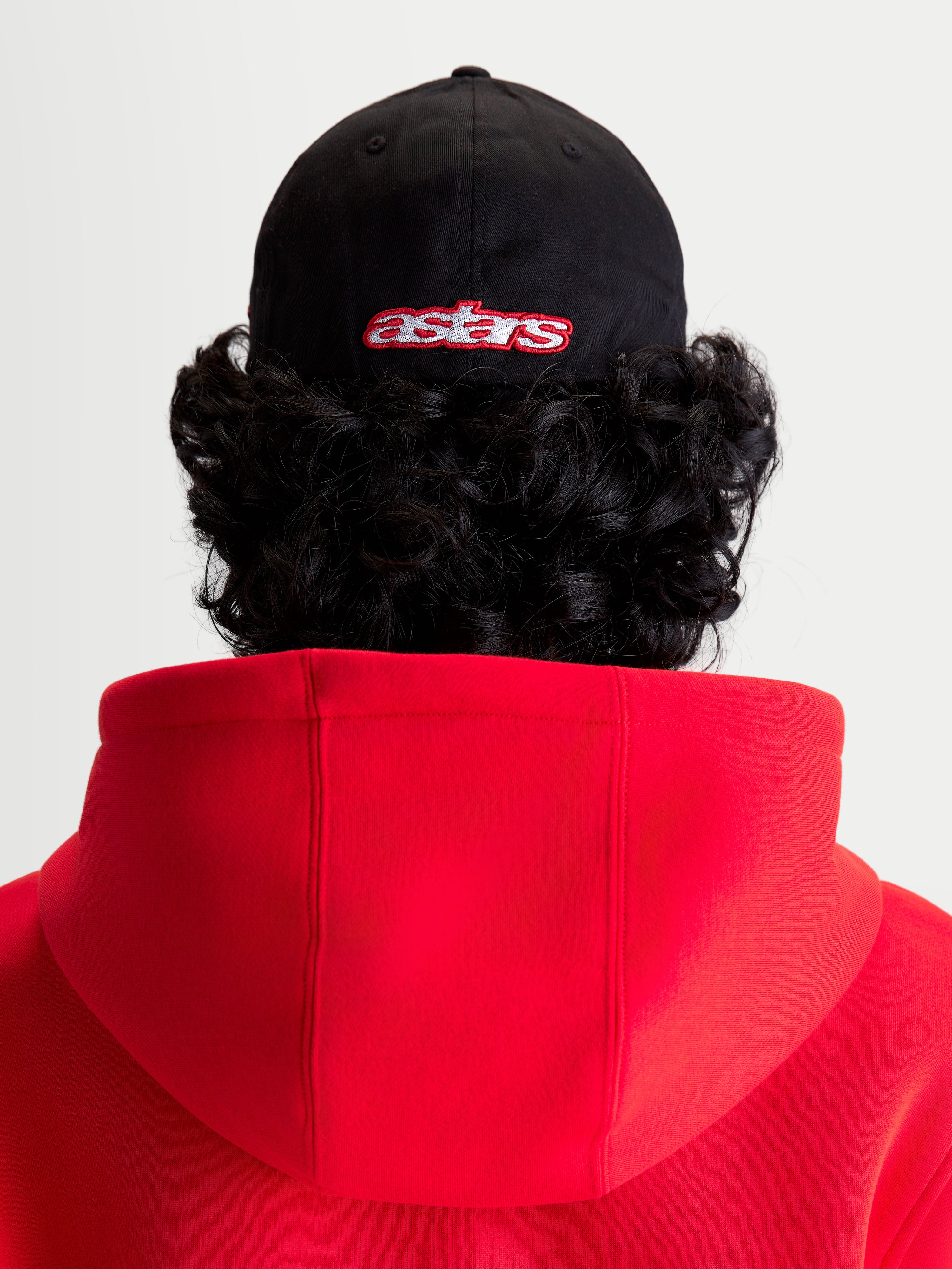 Alpinestars Lineout keps, sportswear keps sedd bakifrån på modell, svart med röd broderad astars-logotyp, strukturerad krona och twillkonstruktion, sportig design