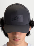 Alpinestars Algo Perf Adjustable keps, mörkgrå sportkeps för vardagsbruk med böjd skärm, strukturerad krona och sonic-weldad Astars-logotyp, sidoperforeringar för luftflöde, sedd framifrån på modell.