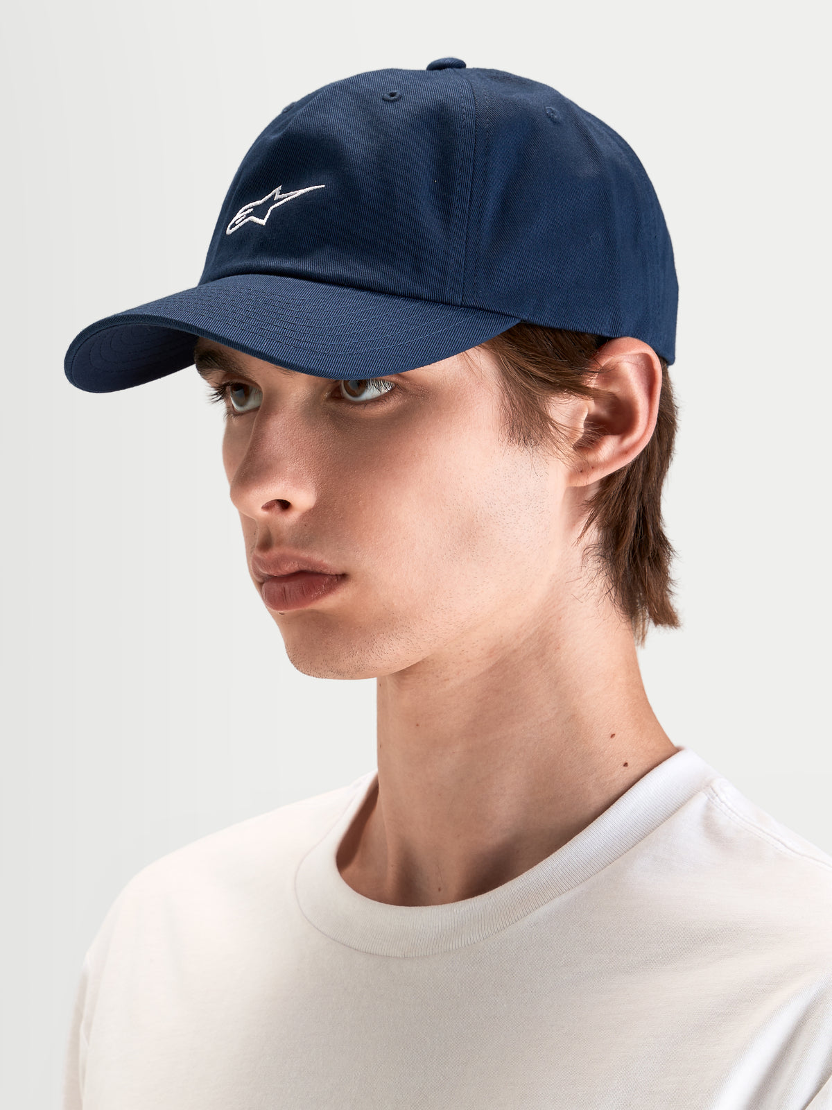 Alpinestars Dylan Dad Hat, casual sportswear cap in navy blue, worn by a model, featuring a curved bill, unstructured low crown, and white Astars logo embroidery on the front