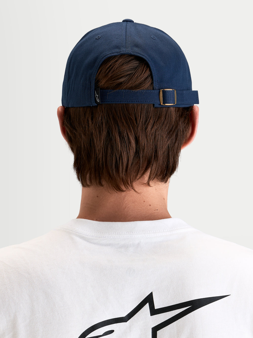 Alpinestars Dylan Dad Keps, marinblå keps med justerbar rem bak med metallspänne och liten Astars-logotyp, vy bakifrån på modell