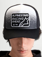Alpinestars Gravel keps, svart och vit truckerkeps för både herr och dam, med en vävd Alpinestars Racing Ahead-patch, strukturerad krona och böjd skärm, frontvy på modell.