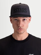 Alpinestars Stadium Snapback Hat, Sportswear Lifestyle Cap, Men's, Dark Gray and Black, featuring a structured crown with front ASTARS logo applique and flat bill design, shown on model.