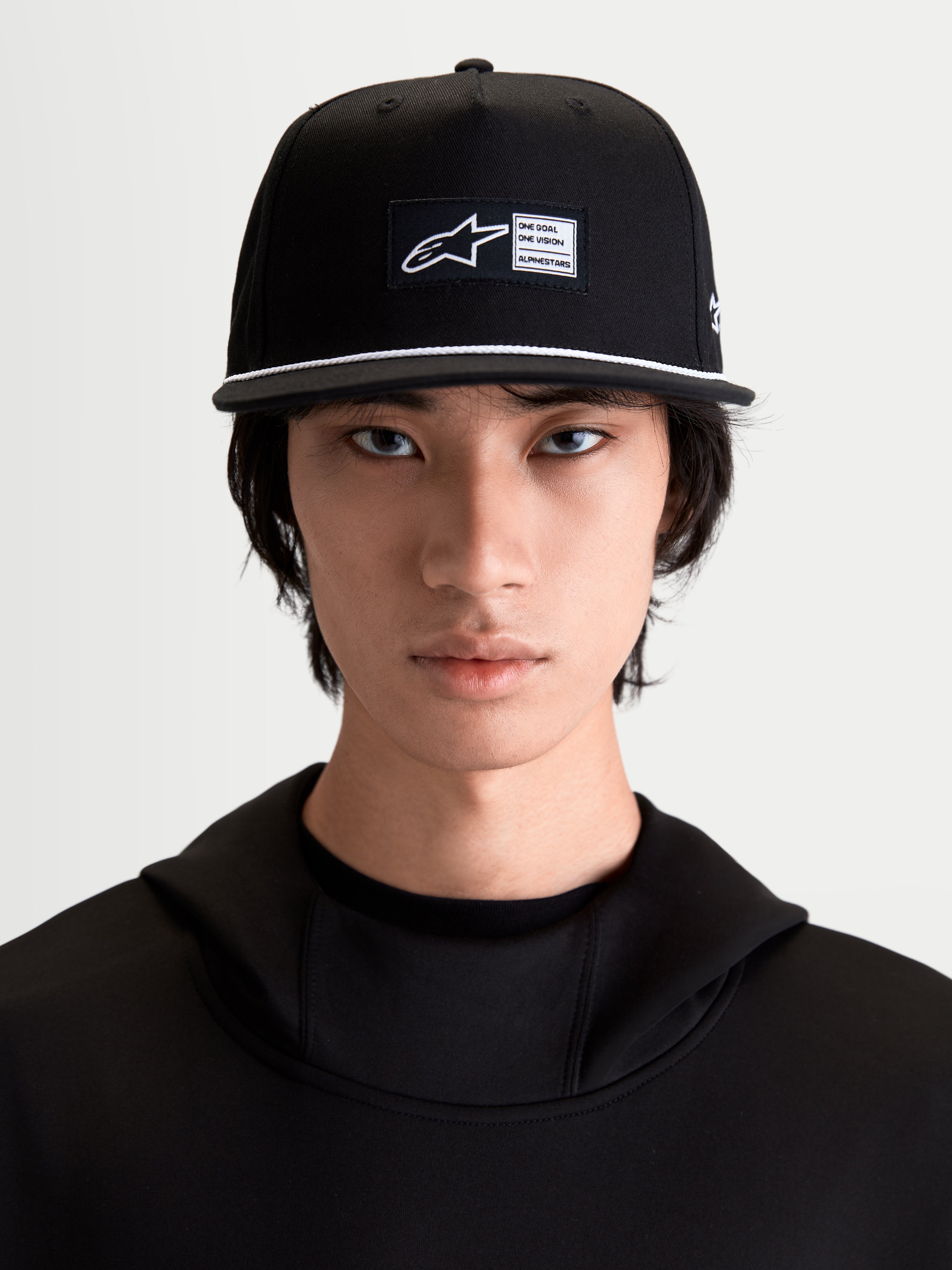 Alpinestars Label Snapback keps, svart och vit sportkeps, platt skärm med vit repsdetalj, vävd etikett framtill, bomullstwill, på modell