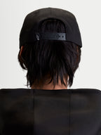 Alpinestars Label Snapback keps, svart sportkeps för dam och herr, baksida på modell som visar justerbar snapback-stängning med liten vit logotyp, slitstark bomullstwill.