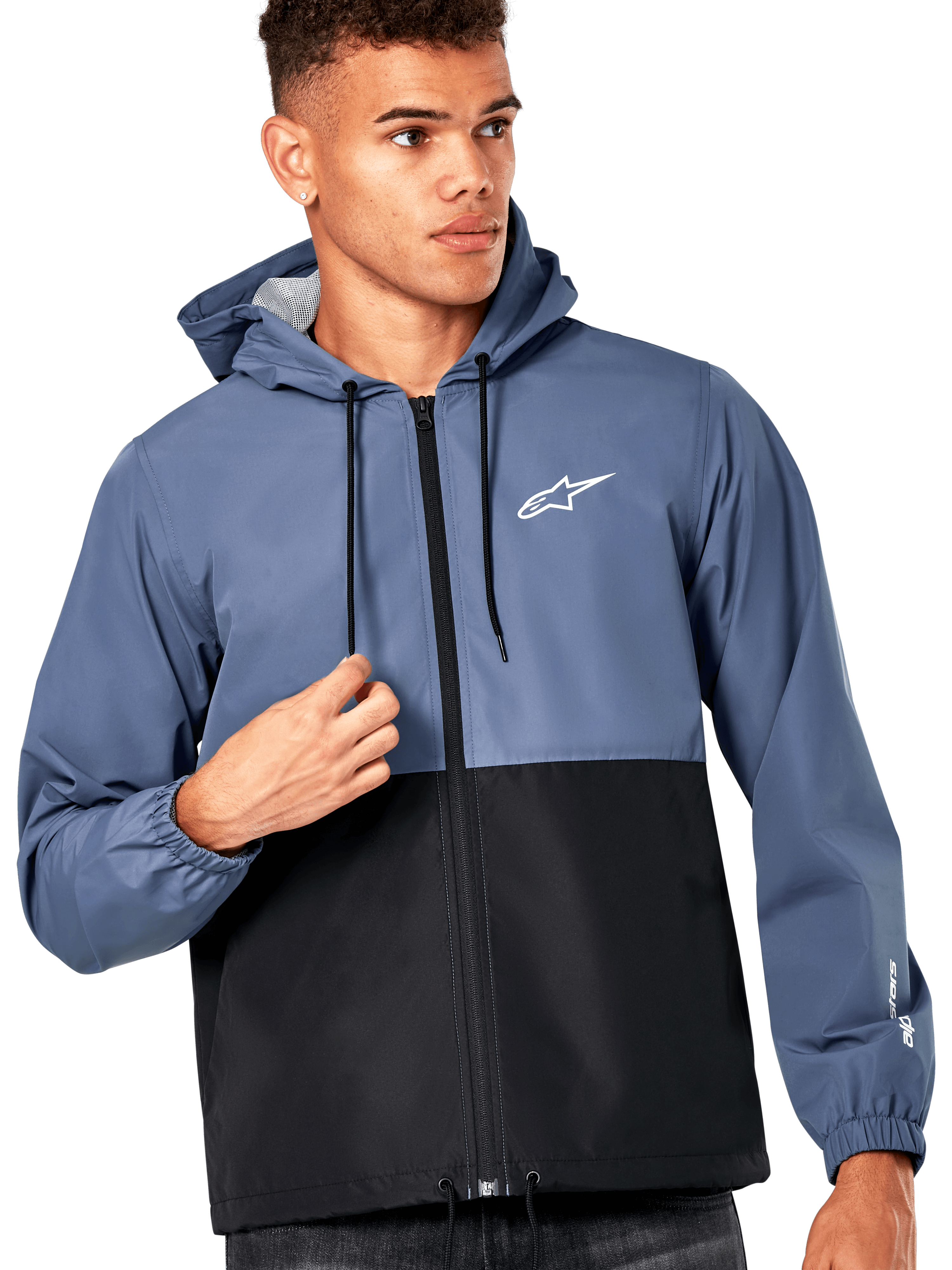 Manlig modell i Alpinestars Speeder vindjacka, blockfärgad design i skifferblått och svart, huva med svarta dragsnören, vit logotyp på bröstet, avslappnad motorsportinspirerad vindjacka