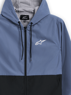 Alpinestars Speeder vindjacka, skifferblå och svart, lätt vindjacka med huva, meshfoder med svarta dragsnören, vit Alpinestars-stjärnlogotyp på bröstet, blockfärgad design, avslappnad motorsport-inspirerad streetwear