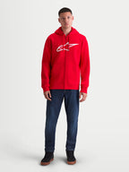 Alpinestars Ageless Zip V3 huvtröja, röd och vit herrhuvtröja i sportswear-fleece med dragkedja, stor vit logotyp på bröstet, dold spiraldragkedja och ribbade muddar, framifrån på modell.