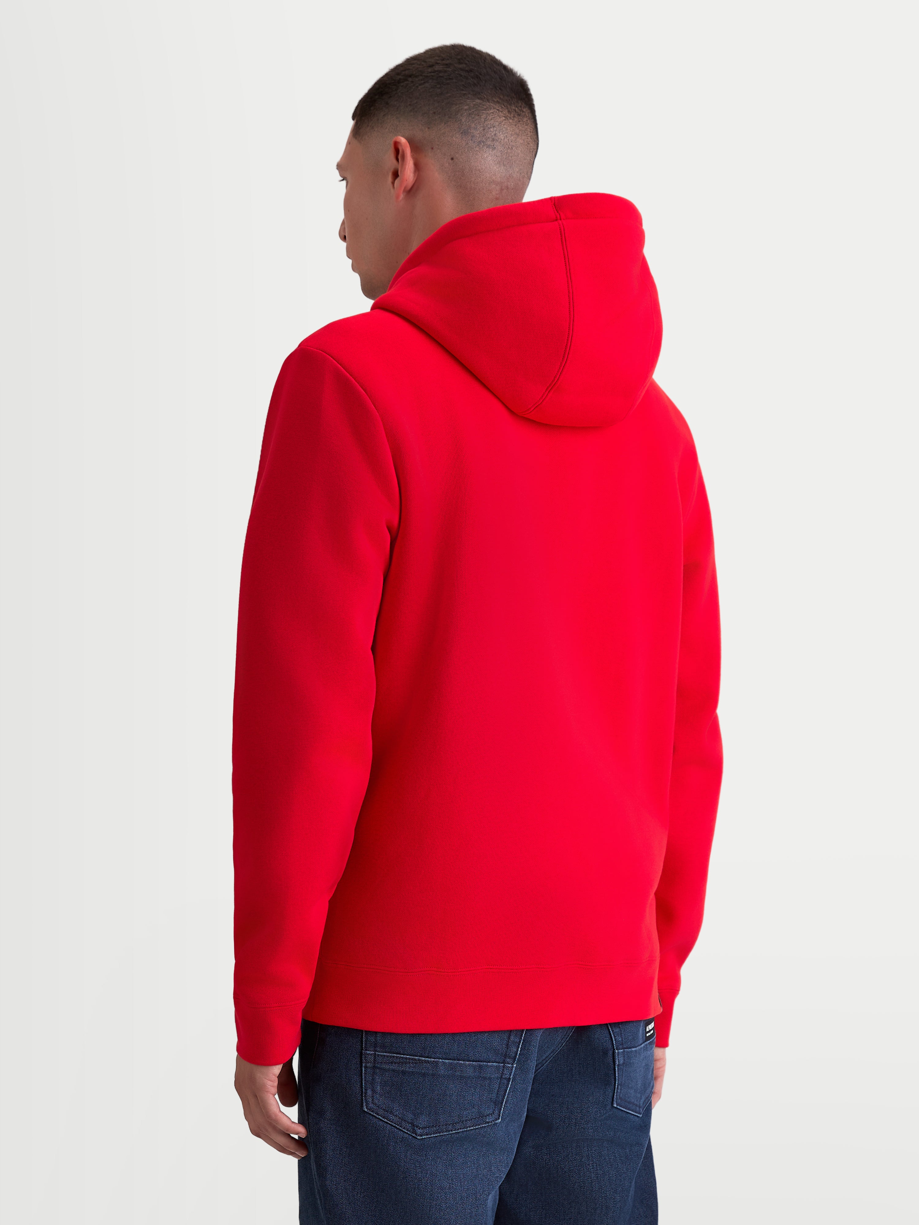 Alpinestars Ageless Zip V3 huvtröja, röd fleecehuvtröja för herrar sedd bakifrån på modell, bekväm design med huva och ribbad fåll för förare och motorsportfans.