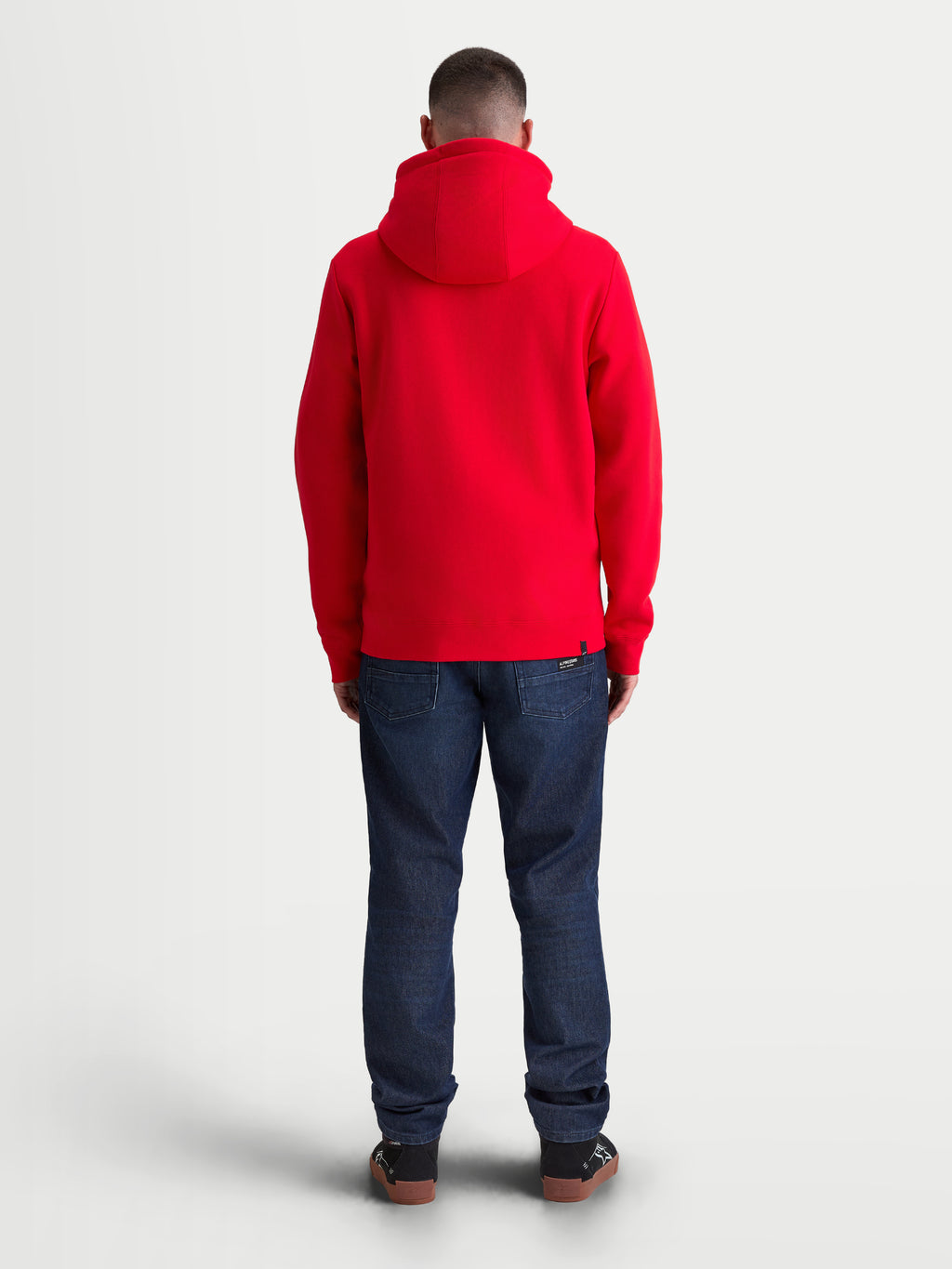Alpinestars Ageless Zip V3 huvtröja, röd sportfleece för herr och dam sedd bakifrån på modell, bekväm design med huva, ribbade muddar och fåll, avslappnad motorsportstil.