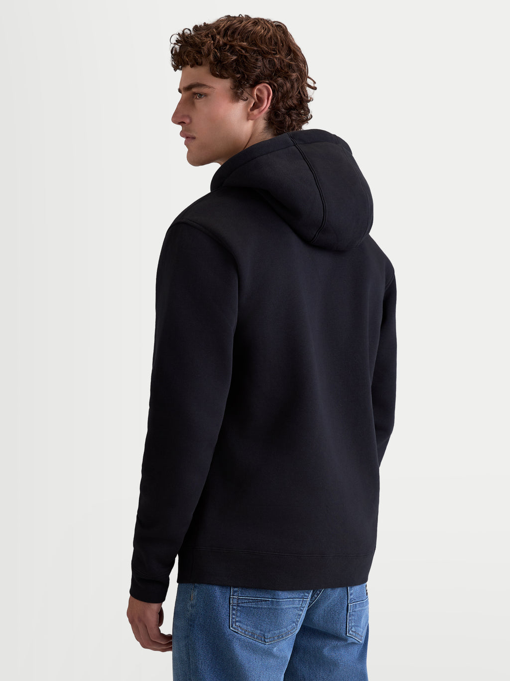 Alpinestars Ageless V3 huvtröja, svart fleecehuvtröja för herrar sedd bakifrån, bekväm pullover i mjuk bomullsblandning med ribbade muddar, sportiga vardagskläder för motorsportentusiaster.
