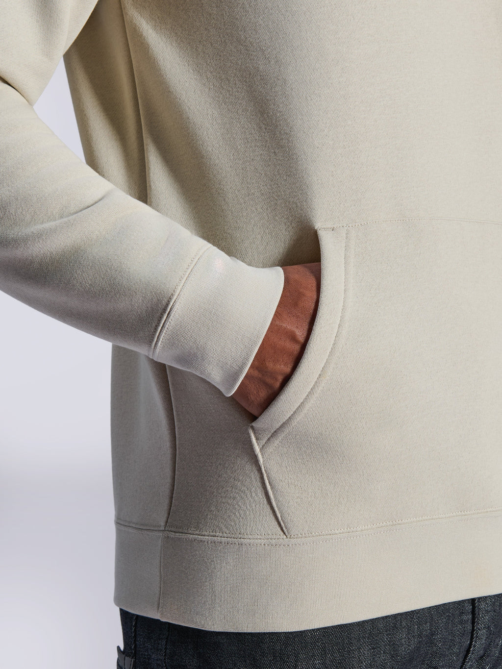 Alpinestars Ageless V3 Hoodie, close-up detail of front kangaroo pocket and ribbed cuff, off-white fleece, casual motorsport-inspired streetwear