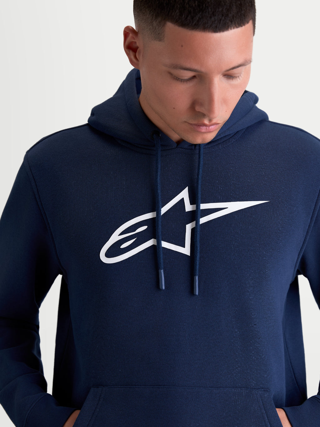 Alpinestars Ageless V3 huvtröja, mörkblå herrtröja i mjuk fleece med vit broderad Alpinestars-logotyp på bröstet, huva med dragskor, avslappnad motorsport-lifestyle.