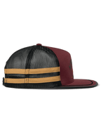 Alpinestars Backline Trucker Hat, Brick Black and Mustard, side profile view, dark red twill front with black mesh back and yellow side stripes, flat bill with black suttache trim, casual motorsport-inspired headwear