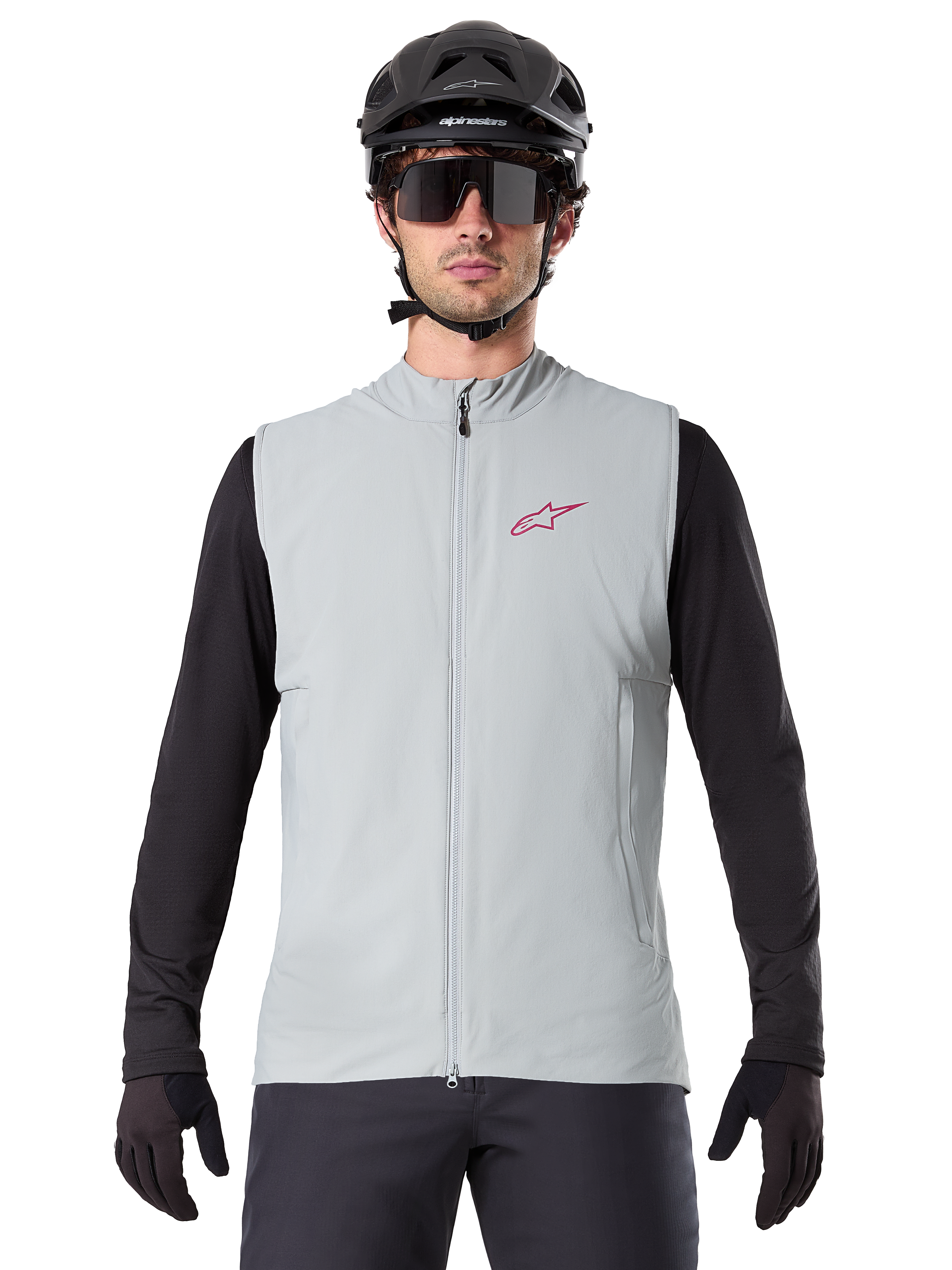 Alpinestars A-Dura Termisk Väst, cykelväst, titaniumgrå, bärs med en svart långärmad tröja och svart cykelhjälm, röd Alpinestars-stjärnlogotyp på bröstet, lätt och isolerad för mountainbikecykling