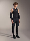 Alpinestars A-Motion Plasma skyddsväst, ärmlös svart och kamouflagemönstrad MTB-skyddsväst, helkroppsbild av modell som bär västen med ärmskydd och knäskydd, dragkedja framtill med vit Alpinestars-logotyp, högpresterande utrustning för mountainbikecykling