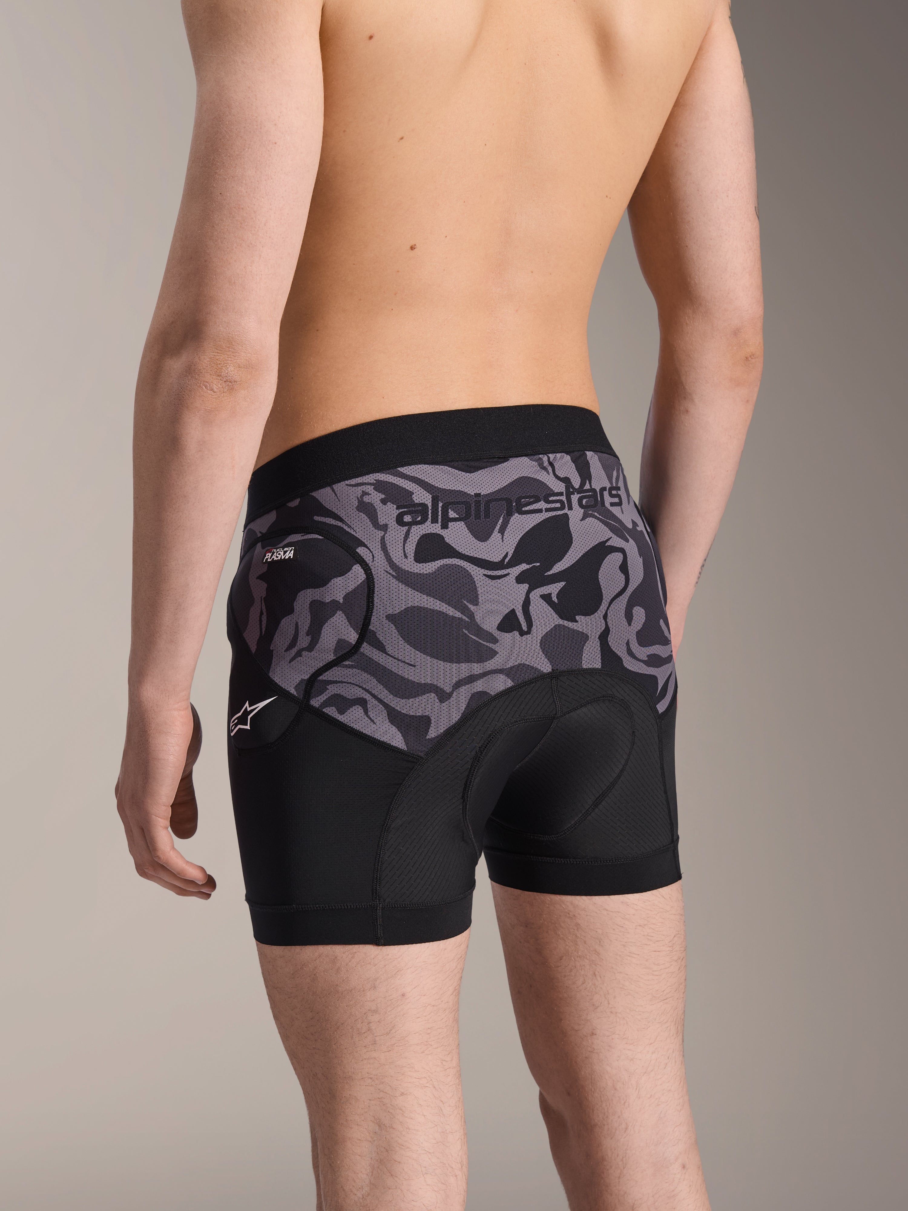 Alpinestars A-Motion Plasma skyddsboxershorts, Black Camo cykelskyddsshorts, baksida som visar ergonomisk design med Nucleon Plasma-höftskydd och chamoisdyna, andningsbart meshmaterial med Alpinestars-logotyp på midjebandet