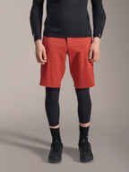 Alpinestars A-Motion Plasma Knee Sleeve, svarta knäskydd för MTB, bärs med röda shorts och svart långärmad tröja, ergonomisk design med smal profil, lättviktskonstruktion i mesh för terrängkörning