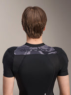 Alpinestars A-Motion Plasma skyddsjacka - kortärmad, baksida av överkroppen, svart med grå kamouflagepanel över axlarna och Alpinestars-logotyp, ventilerande stretchmesh-konstruktion för MTB-skydd