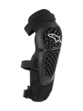 Alpinestars Bionic Plus Knee/Shin Protectors, Black, Off-road and MTB Protection, featuring a perforated honeycomb shell with a white Alpinestars logo, dual adjustable straps, and 3D mesh ventilation, ergonomic curved design