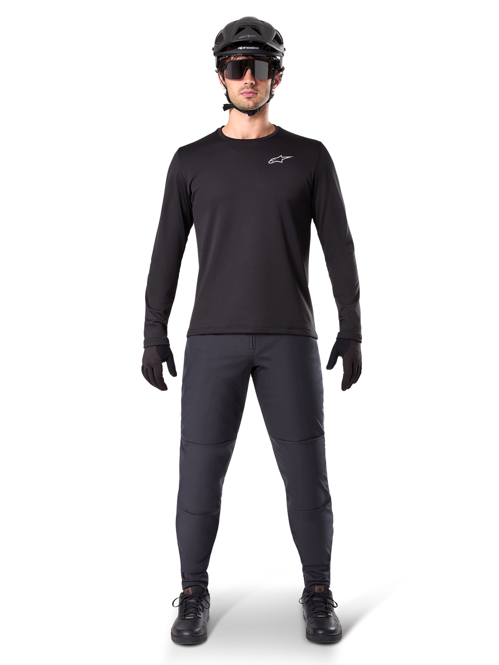 Alpinestars A-Dura Thermal Byxor, svarta, bärs av en cyklist i komplett mountainbike-utrustning inklusive en svart långärmad tröja, hjälm och solglasögon, slitstarka byxor med normal passform för stigcykling i kallt väder