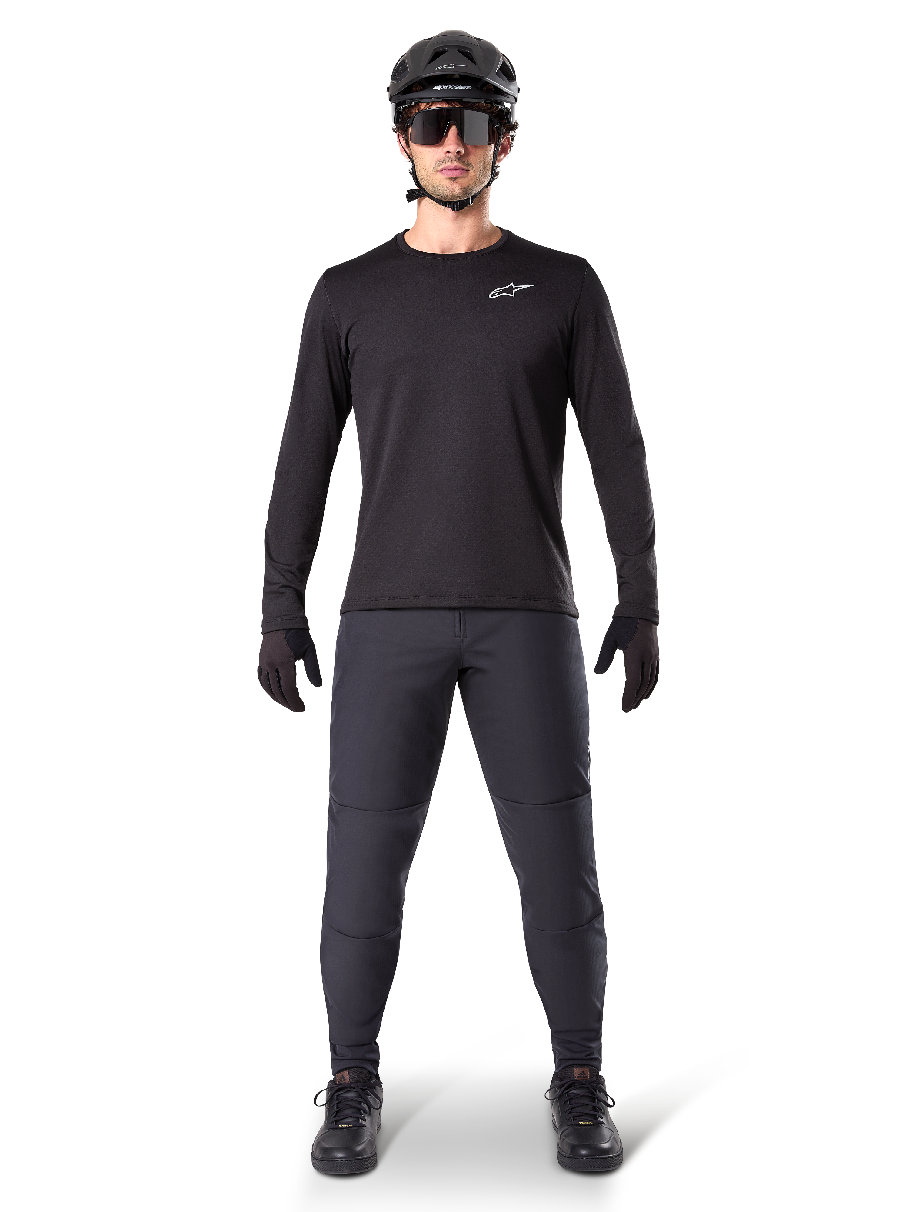 Alpinestars A-Dura Thermal Byxor, svarta, bärs av en cyklist i komplett mountainbike-utrustning inklusive en svart långärmad tröja, hjälm och solglasögon, slitstarka byxor med normal passform för stigcykling i kallt väder