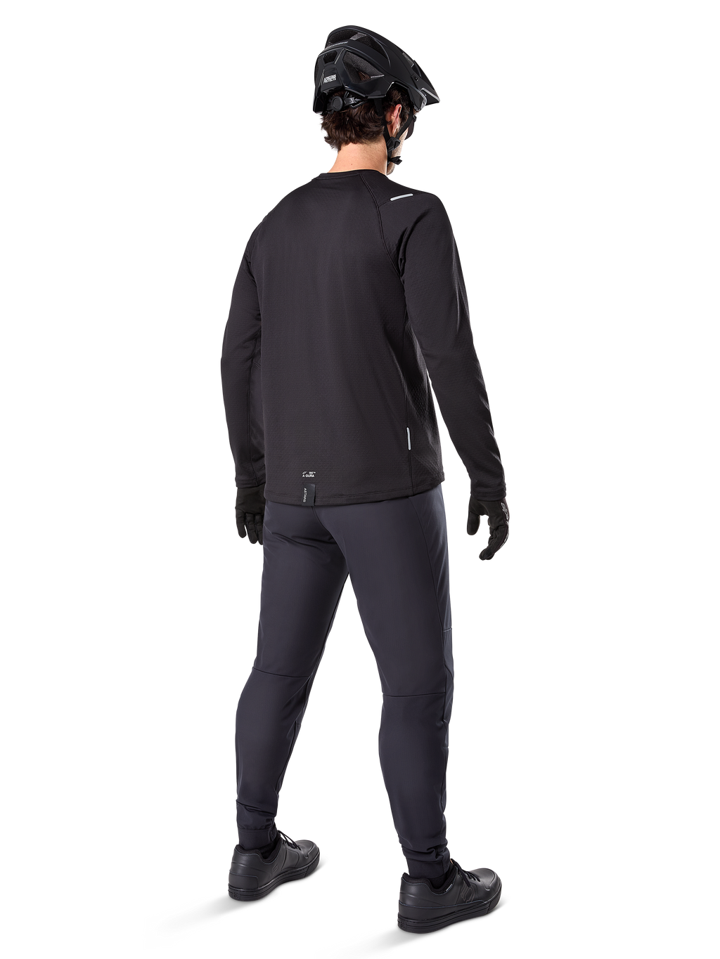 Alpinestars A-Dura Thermal Byxa, mountainbikebyxor, svarta, sedda bakifrån bärs med en matchande långärmad tröja, svart MTB-hjälm och handskar, teknisk cykelutrustning för kallt väder