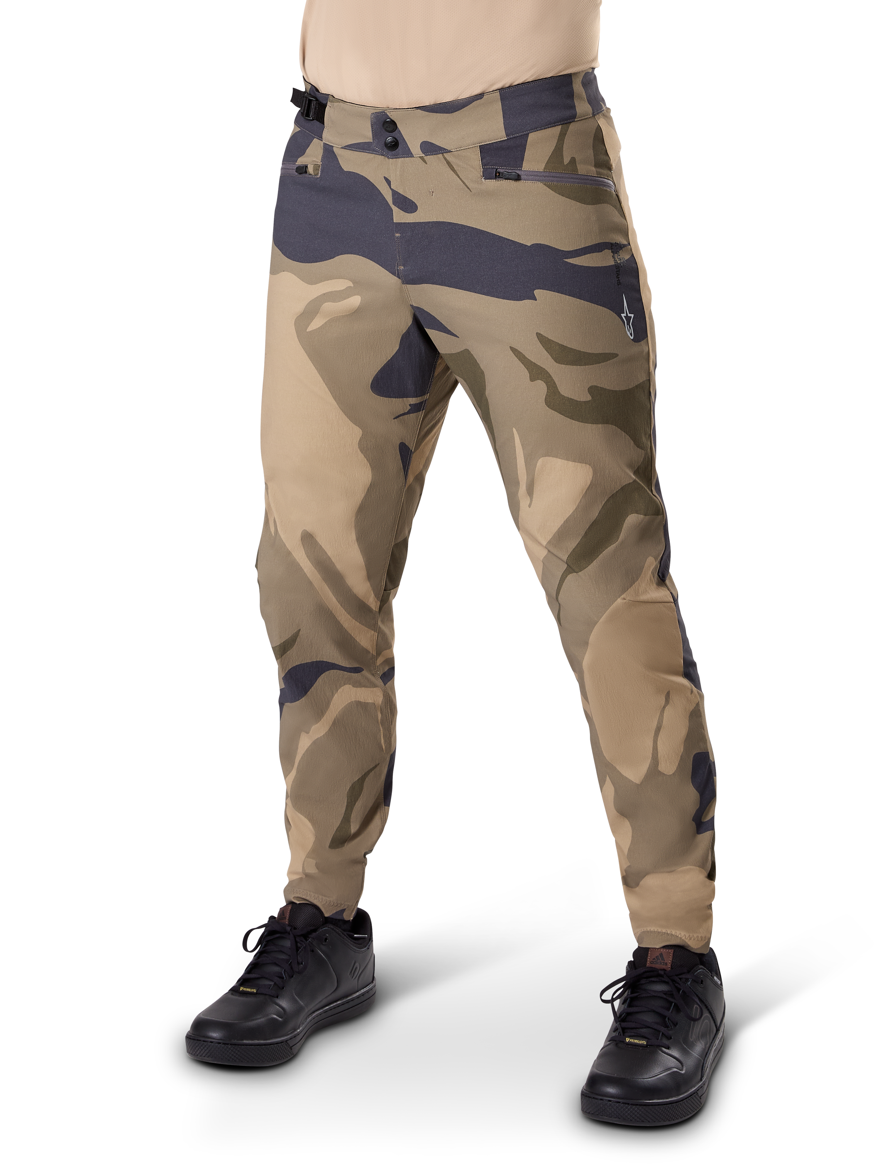 Alpinestars A-Dura Camo Pant, MTB-byxor, brunt kamouflagemönster, har dubbel knäppning och blixtlåsförsedda fickor, normal passform för terrängcykling, bärs med svarta skor
