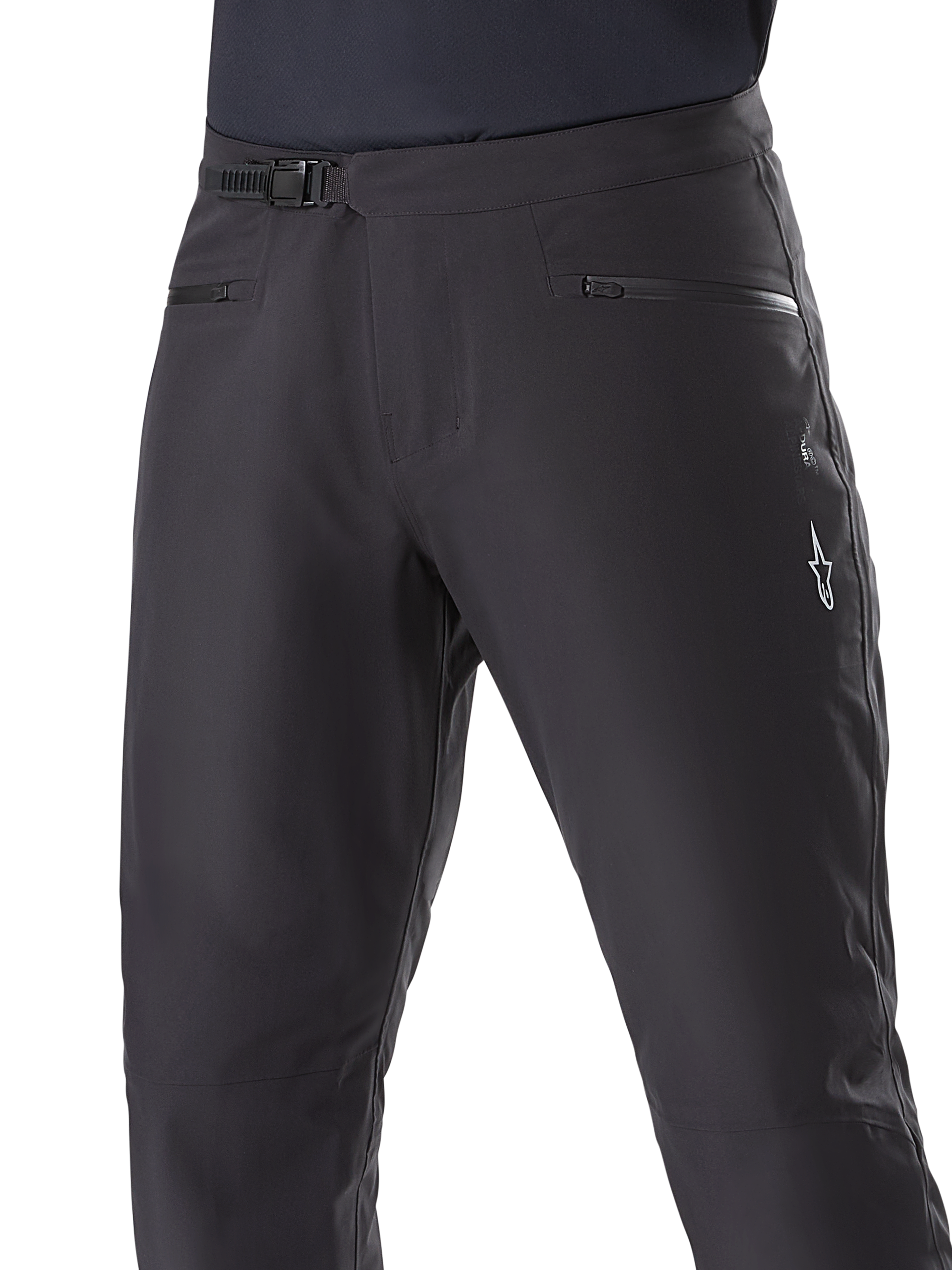 Alpinestars A-Dura Waterproof Pants, mountainbike-byxor, svarta, närbild av midjan som visar spärrspänne och fickor med dragkedja, vit Alpinestars-logotyp på låret, slitstarkt textilmaterial för terrängcykling i vått väder