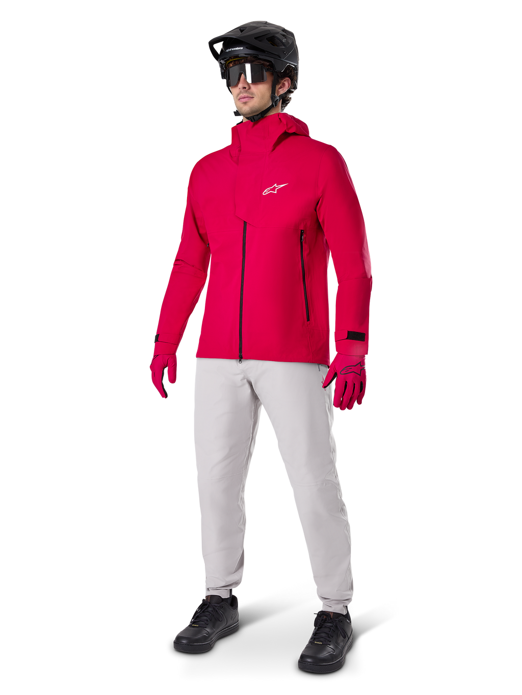 Modell iförd Alpinestars A-Dura Waterproof Pants i Titanium-grått, kombinerat med en klarröd vattentät jacka och matchande handskar, svart mountainbikehjälm med goggles och svarta skor, komplett mountainbikeutrustning för våta terrängförhållanden