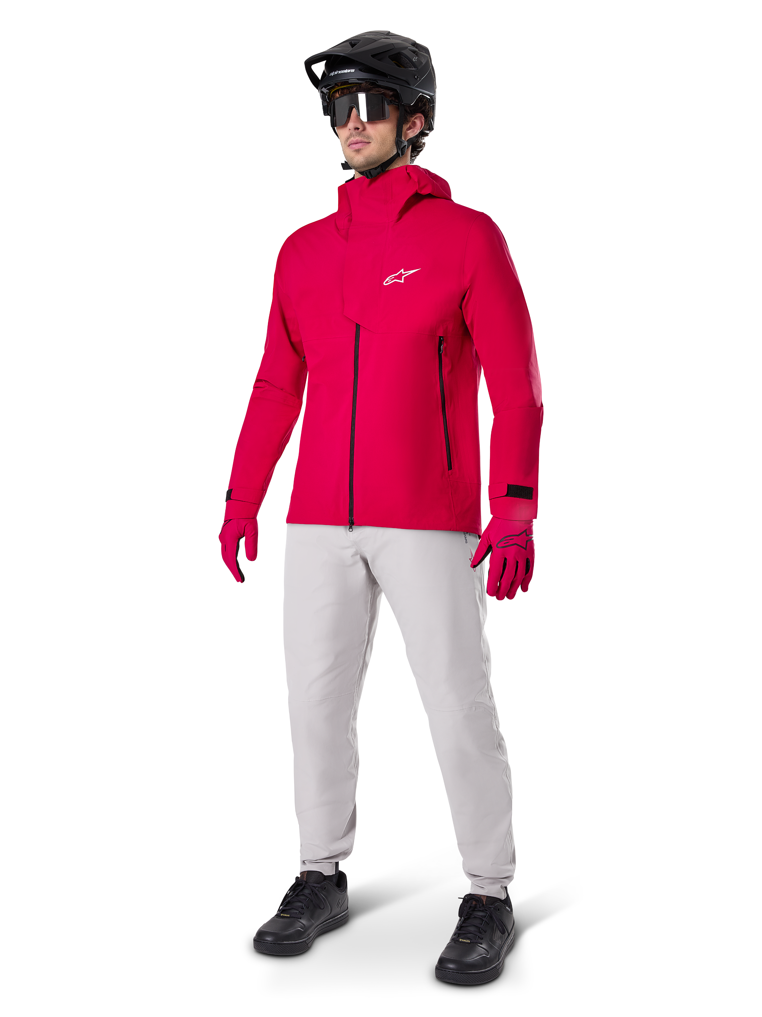 Modell iförd Alpinestars A-Dura Waterproof Pants i Titanium-grått, kombinerat med en klarröd vattentät jacka och matchande handskar, svart mountainbikehjälm med goggles och svarta skor, komplett mountainbikeutrustning för våta terrängförhållanden
