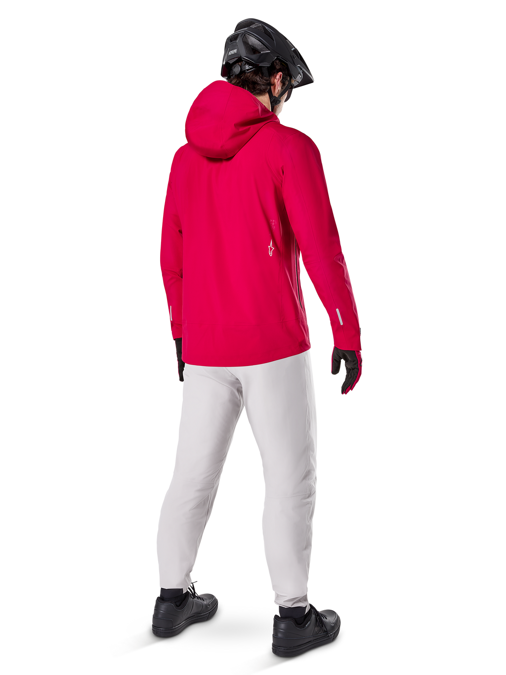 Alpinestars A-Dura Waterproof Pants i Titanium, bakifrån av en cyklist som bär de ljusgrå tekniska mountainbikebyxorna med en klarröd huvjacka och svart hjälm, slitstark vattentät utrustning för cykling i våta förhållanden