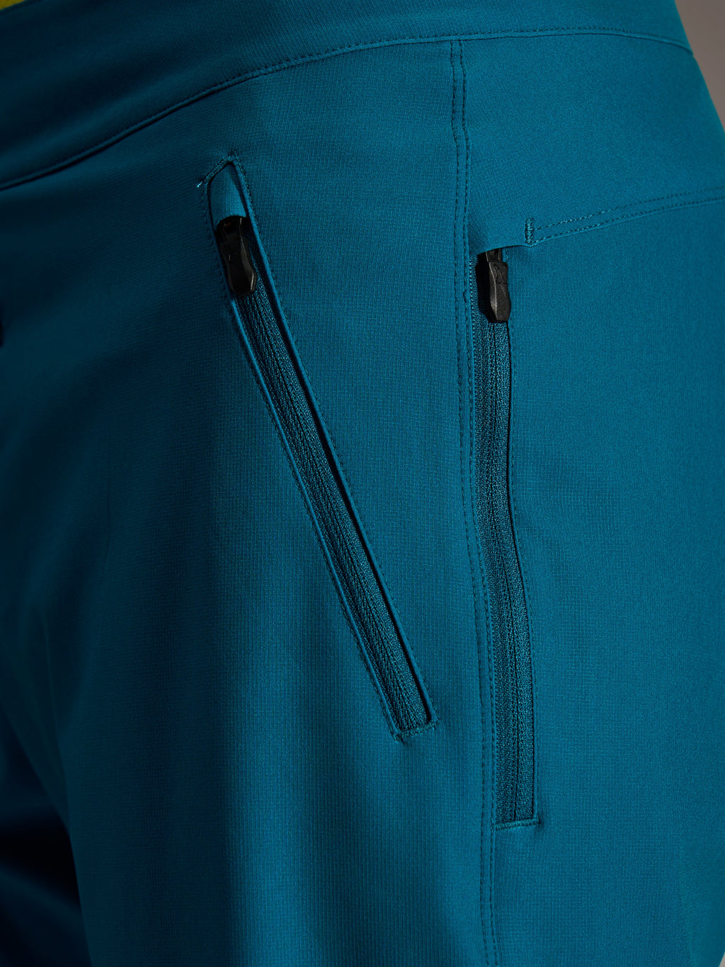 Dubbla sidofickor med dragkedja på blågröna Alpinestars A-Dura Ride Shorts i slitstarkt 4-vägs stretchmaterial.