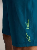 Blågröna A-Dura Ride MTB-shorts med limegrön Alpinestars-logotyp på sidan, tillverkade i stretchvävt tyg.