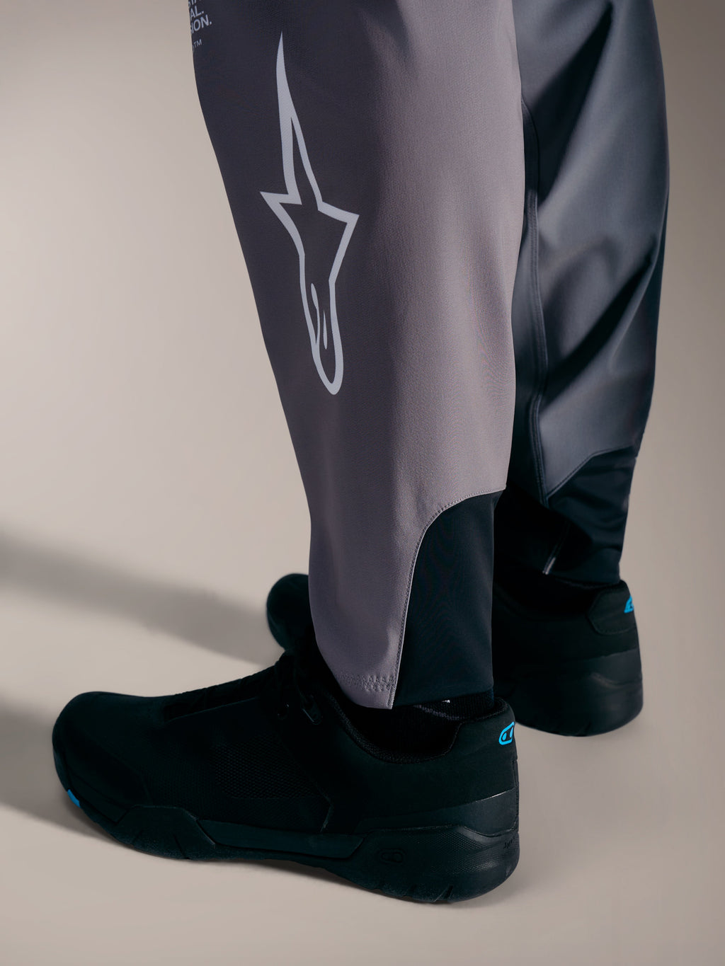 Grå A-Supra Elite-byxor med vit Astars-logotyp och stretchmuddar för MTB-racing.