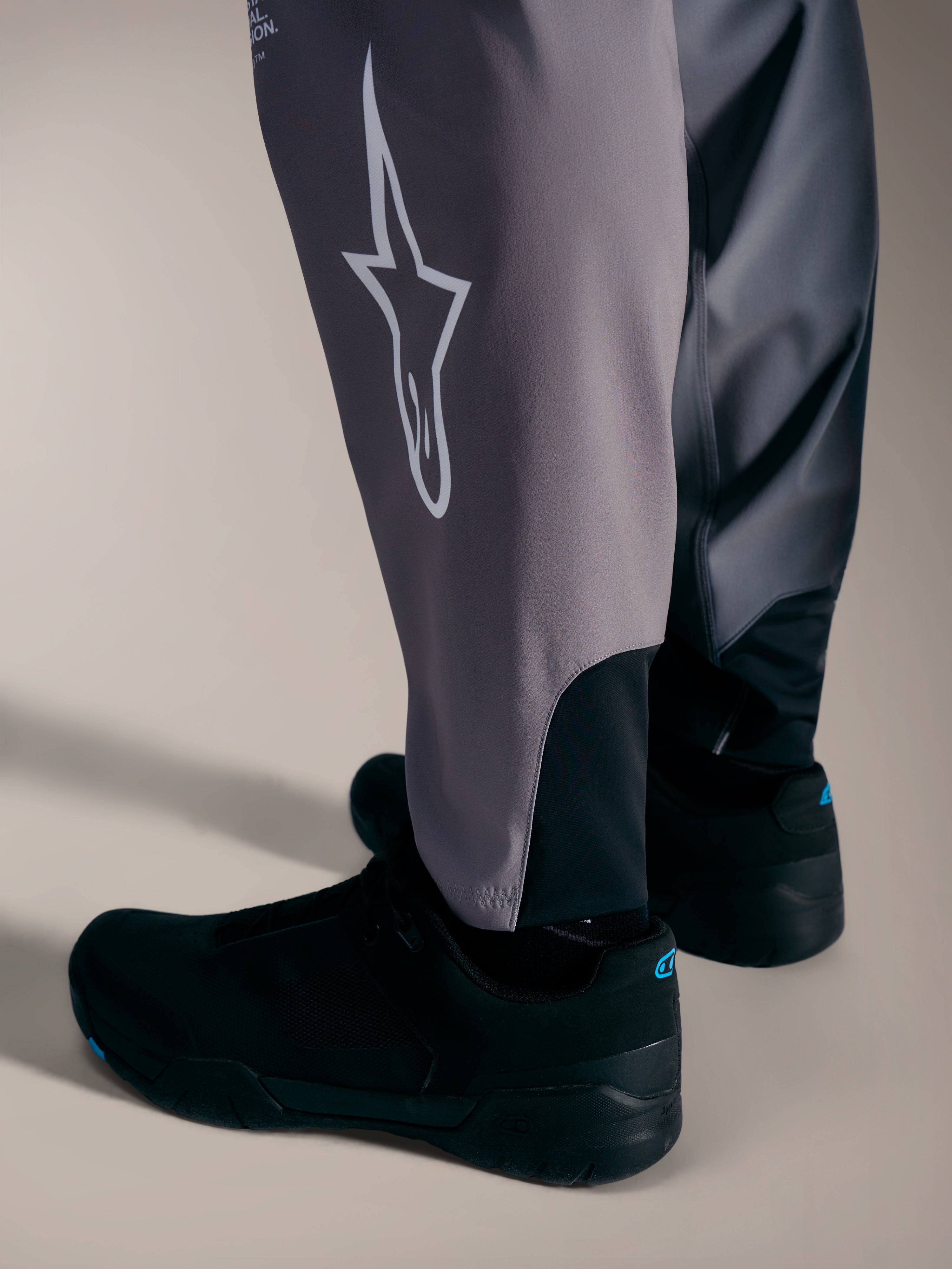 Grå A-Supra Elite-byxor med vit Astars-logotyp och stretchmuddar för MTB-racing.