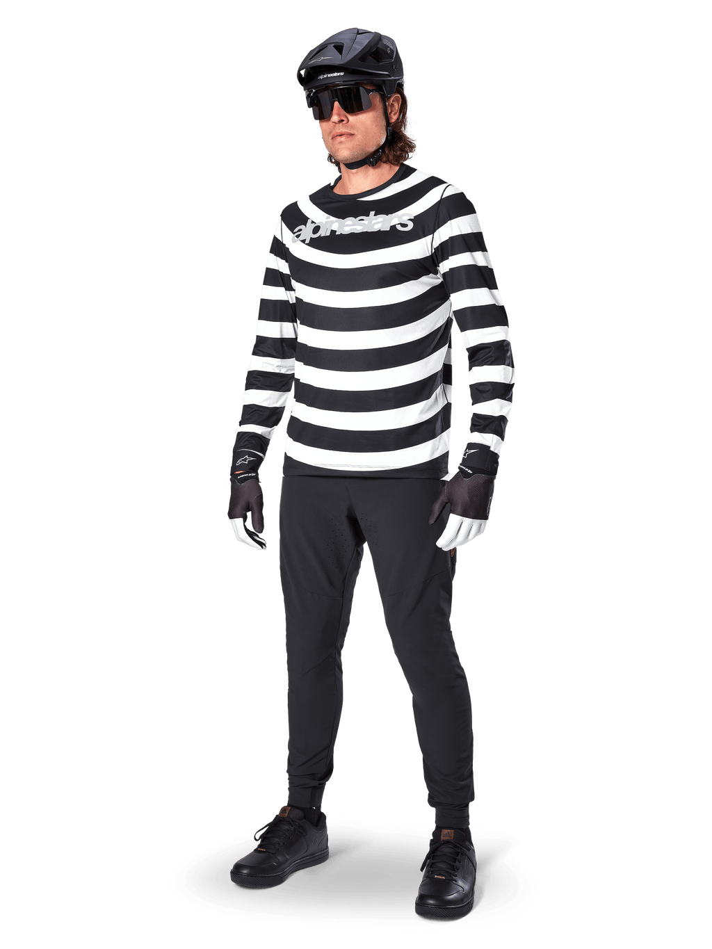 Alpinestars A-Aria Elite Pants, Black MTB Pants, worn by a rider with a black and white striped long-sleeve jersey, black helmet, sunglasses, and black and white gloves, performance gear for off-road cycling