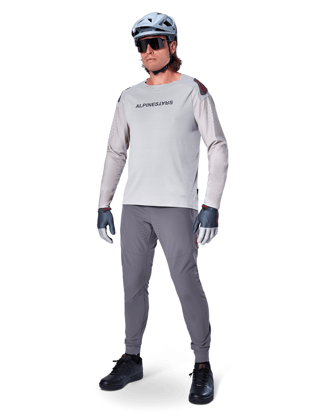 Alpinestars A-Aria Elite byxor, mörkgrå MTB-byxor, burna av en cyklist med en ljusgrå långärmad tröja och grå hjälm, med laserskuren ventilation på låren och en avsmalnande prestandapassform för mountainbikecykling.