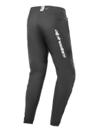 Alpinestars A-Dura Elite-byxor, mountainbikebyxor, svarta, vy snett bakifrån med Alpinestars-logotyp i silver på låret, ficka med dragkedja och elastiska muddar, slitstark teknisk utrustning för MTB