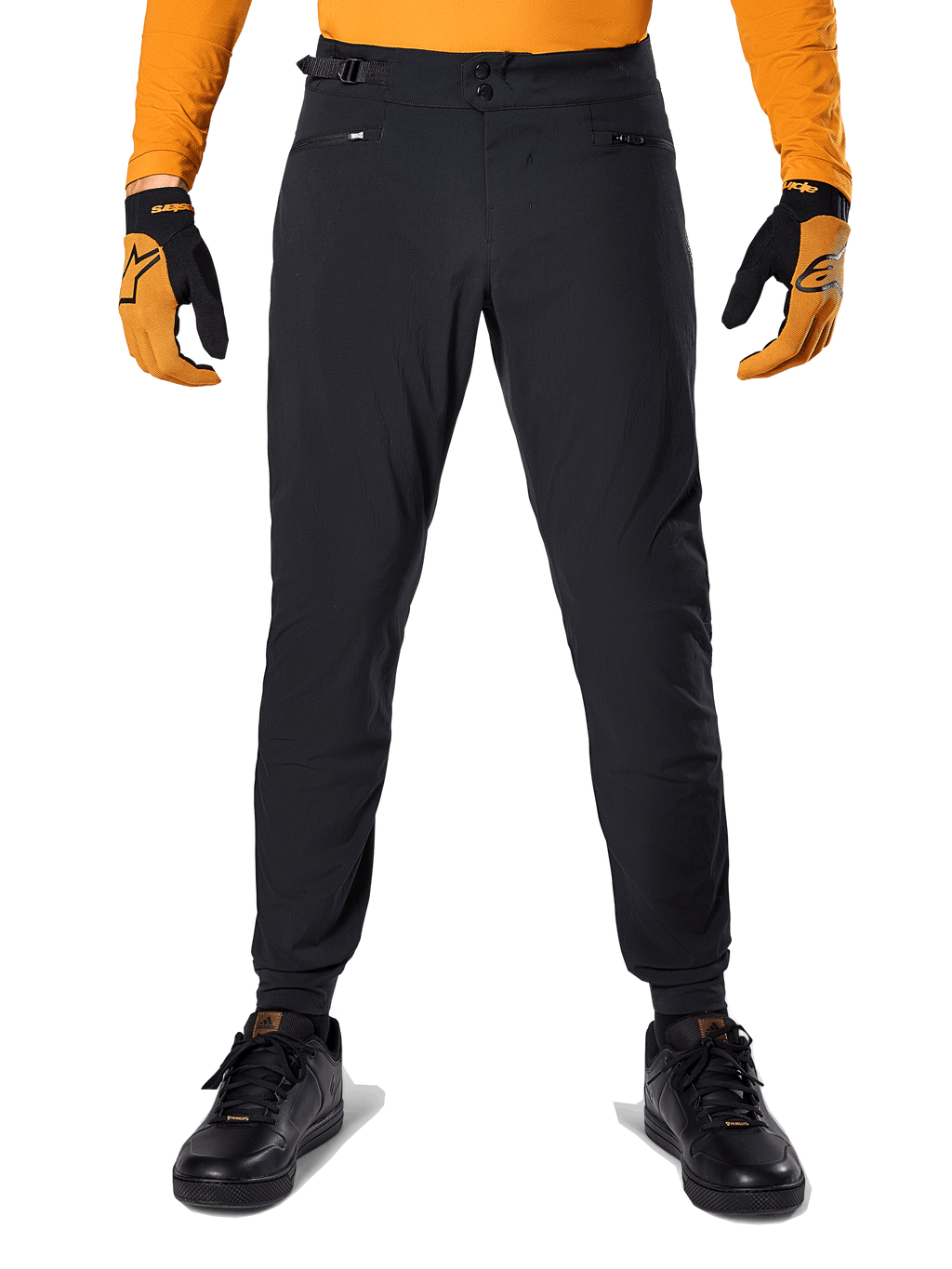 Alpinestars A-Dura-byxor, MTB-byxor, svarta, bärs med en orange långärmad tröja och svart-orangea handskar, med dubbel tryckknappsstängning och sidojustering i midjan, slitstarkt textilmaterial för terrängcykling