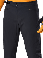 Alpinestars A-Dura Pants, svarta MTB-cykelbyxor, närbild med dubbel tryckknappsstängning i midjan, justerbar sidostängning och blixtlåsförsedda fickor, matchade med en orange tröja och handskar
