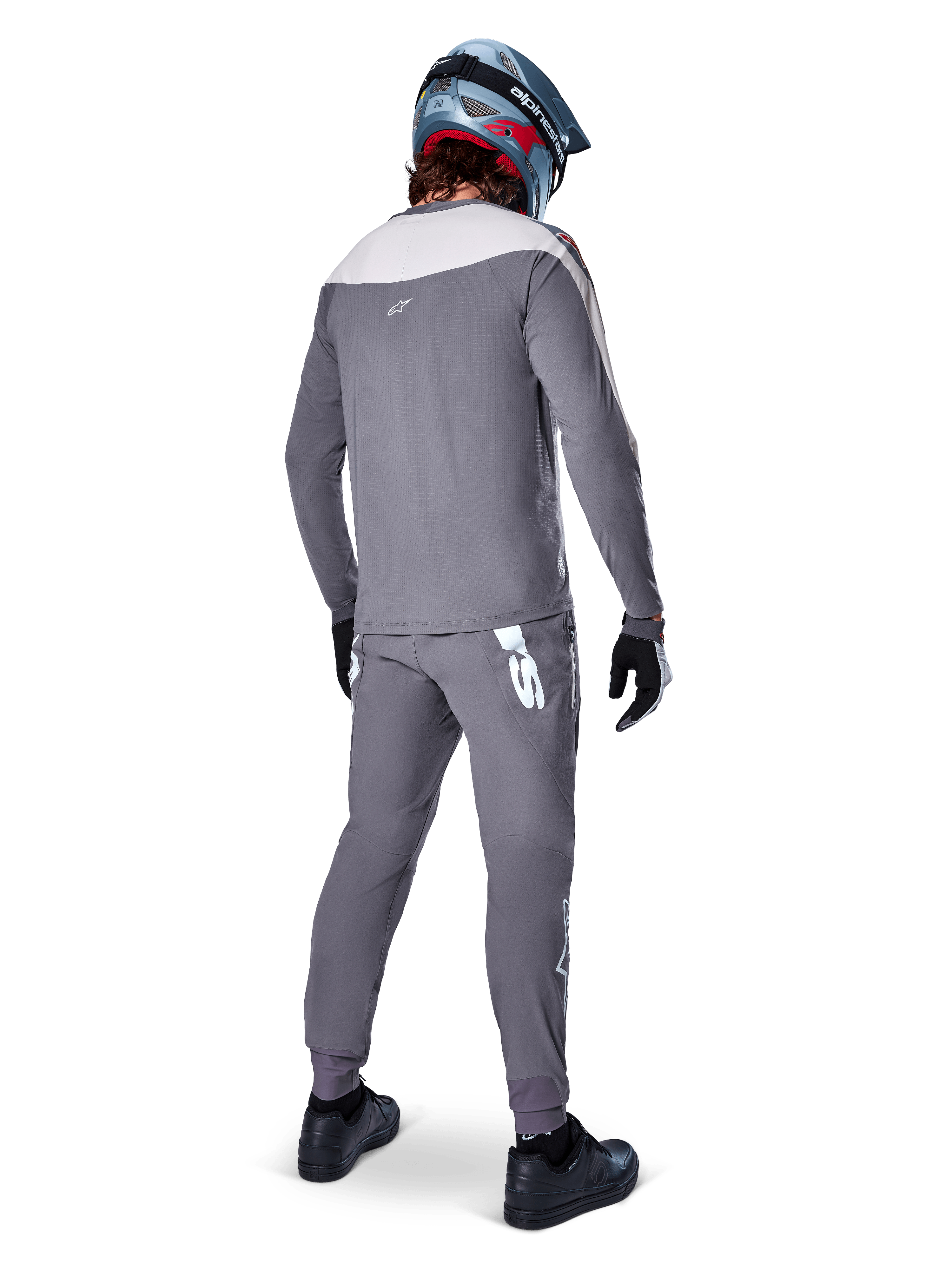 Alpinestars A-Supra Race Pants, Dark Gray, Mountain bike rider from behind wearing full racing kit, gray long-sleeved jersey, dark gray pants with white MX-inspired logo on back yoke, gray and blue helmet, black shoes, designed for MTB performance