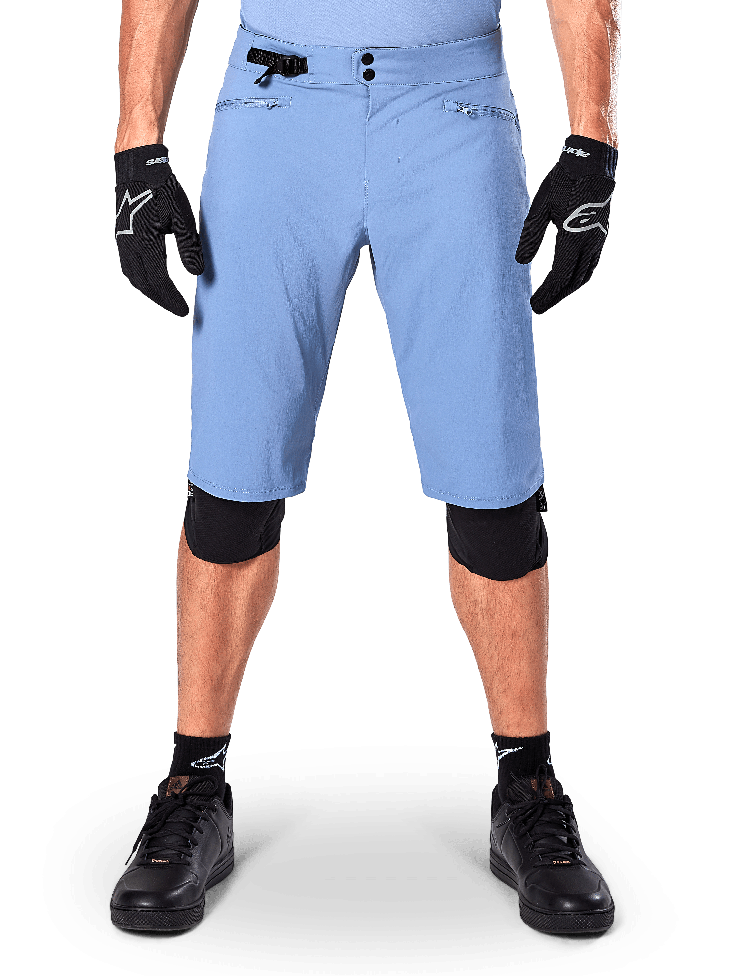 Alpinestars A-Dura Shorts, Infinity Blue mountainbikeshorts, bärs med svarta handskar och knäskydd, med dubbelknäppning och sidoreglering i midjan, teknisk cykelutrustning för MTB
