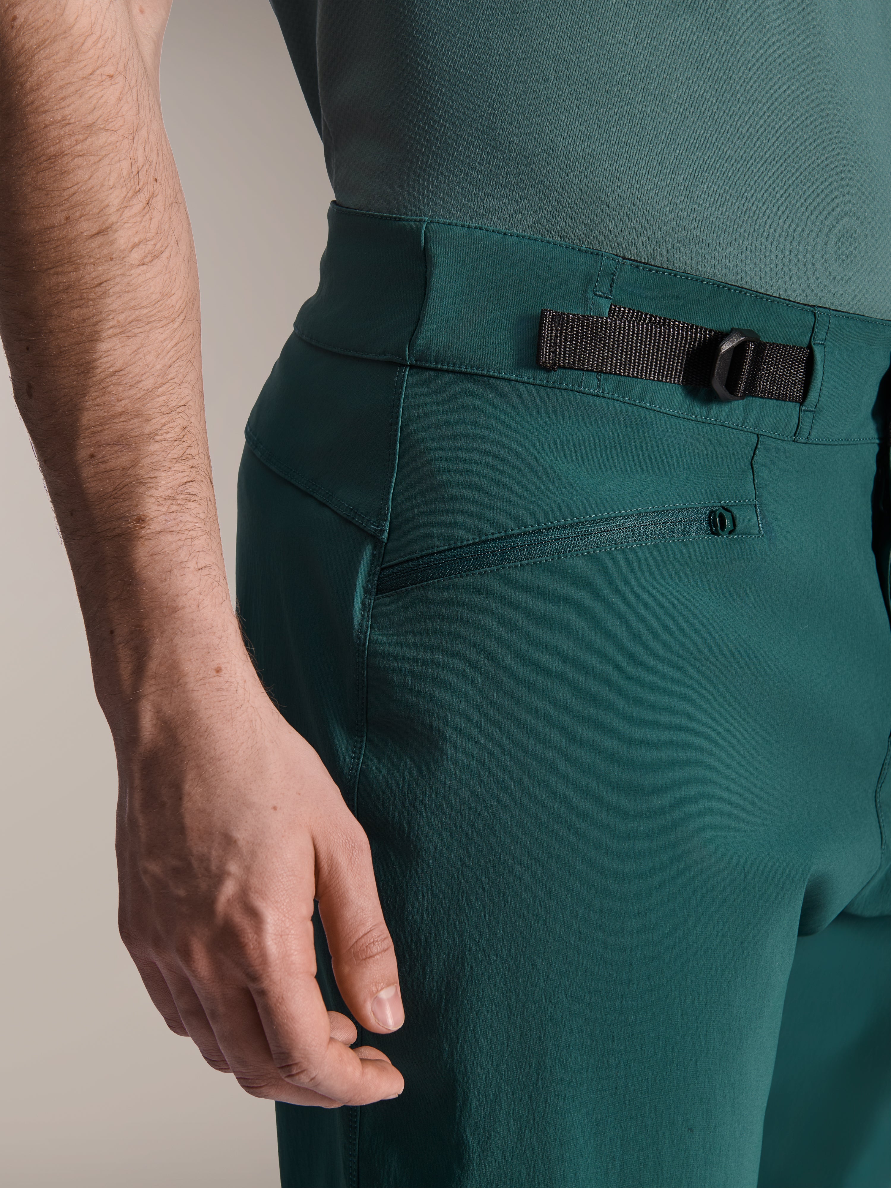 Alpinestars A-Dura Shorts, Dark Pine Green, närbild på det justerbara sidospännet i midjan och en ficka med dragkedja, slitstark funktionsutrustning för mountainbike