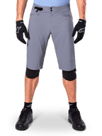 Alpinestars A-Dura Shorts, mountainbikeshorts, mörkgrå, bärs med svarta Alpinestars-handskar och knäskydd, med dubbel tryckknappsstängning och dragkedjeförsedda nätfodrade fickor, slitstarkt 2-vägsstretchtyg för terrängcykling